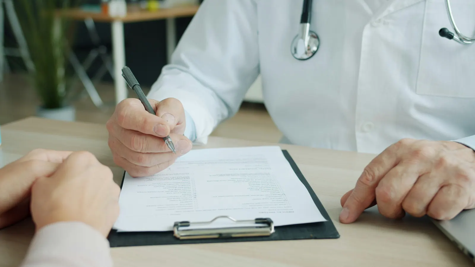 A clinician completing a medical history form with a patient